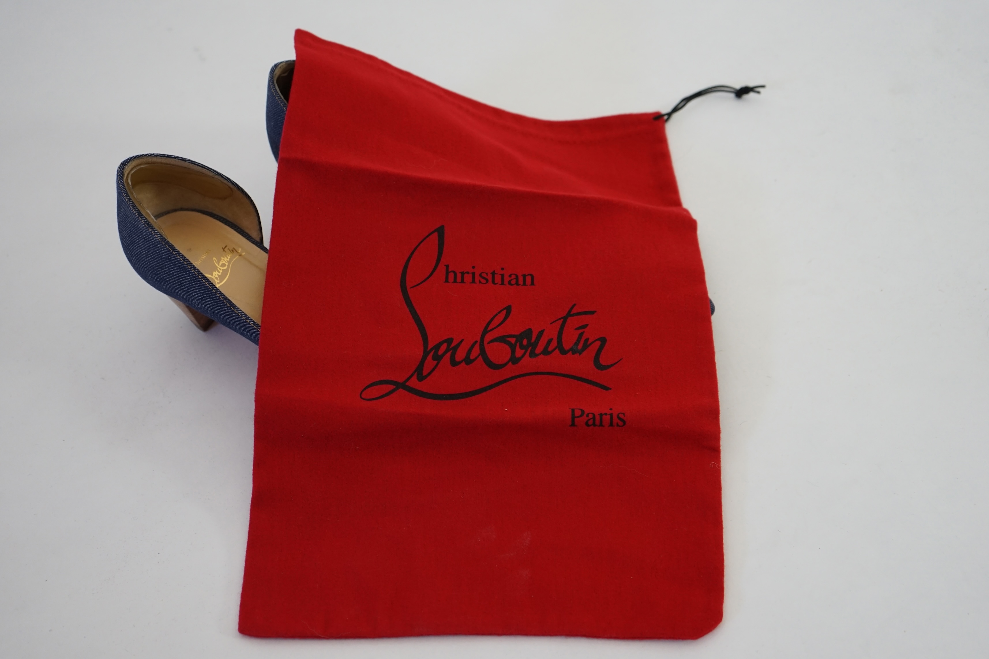 A pair of Christian Louboutin lady's denim pumps with wooden heels, comes with dust bag in original box. Size 39. Proceeds to Happy Paws Puppy Rescue